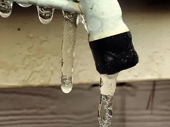 Icicles hanging from a frozen outdoor faucet after a hard freeze