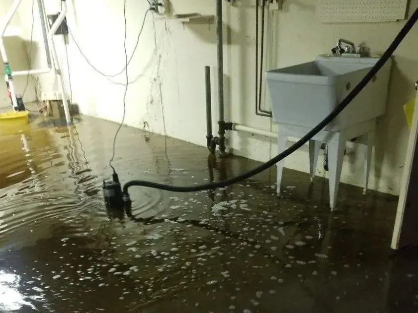 Flooded sump pit and a failed pump in a basement corner