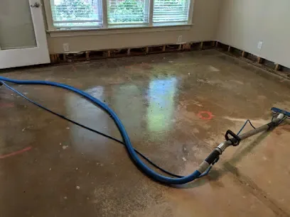 Extraction wand and hose drawing water off a floor after a water heater leak